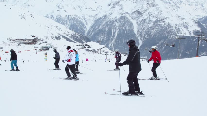 Many skiers ride at alpine mountains on sunny winter day, rider view in motion