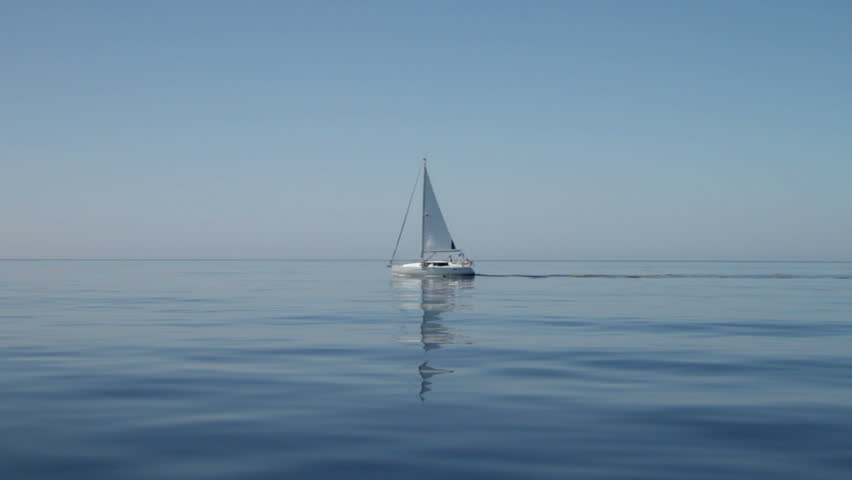 Yacht with reflection motor sails across calm still blue water in the Mediterranean on September 28, 2012 in the Ionian Islands. 