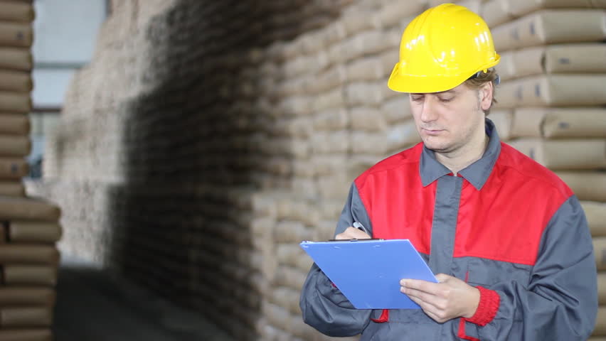 Worker writing results in warehouse, sugar refinery