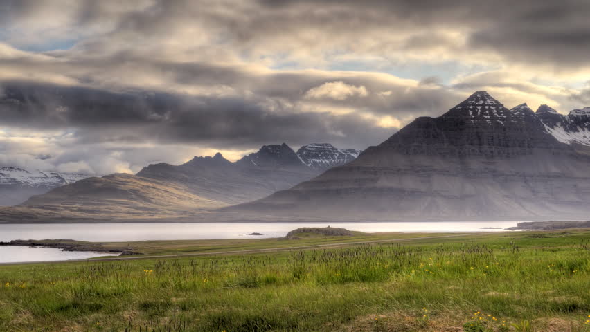 HD video of timelapse clouds at sunset (midnight sun) over a mountain range and fjord in Iceland. HDR, HD timelapse video