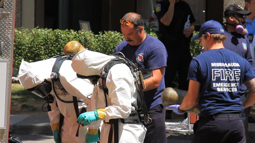 MISSISSAUGA, CANADA - JULY 1 2012: Police in hazardous materials suits working outside an apartment building in Mississauga, Ontario, Canada where a "suspicious death" has occurred.