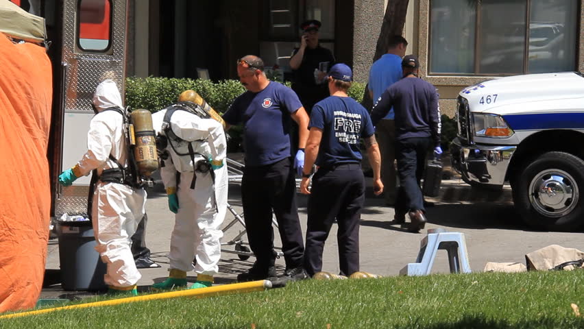 MISSISSAUGA, CANADA - JULY 1 2012: Police in hazardous materials suits working outside an apartment building in Mississauga, Ontario, Canada where a "suspicious death" has occurred.