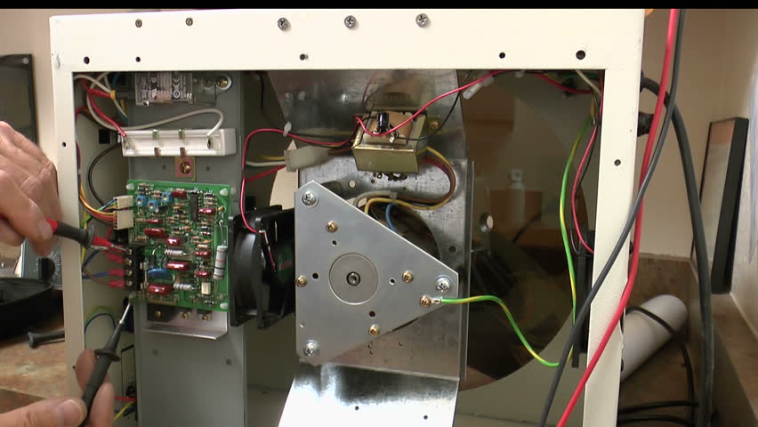 Biomedical service technician troubleshoots centrifuge printed circuit board with a voltmeter. 1080p