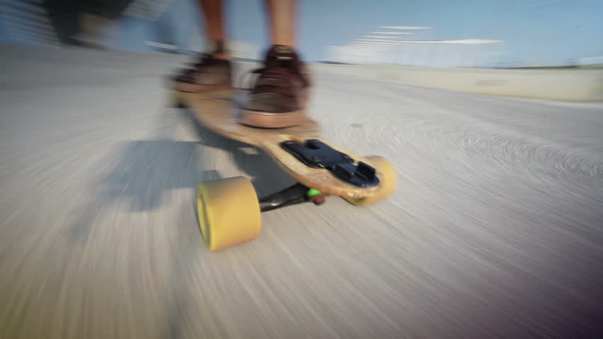close up of the feet of a guy on his longboard skate,  changing planes between left and right side. Barcelona, Spain.
