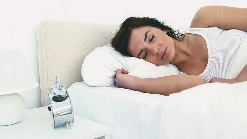 Woman being sad to wake up in a bedroom