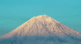 Volcano top. It is visible as on its slopes the wind blows and drags snow