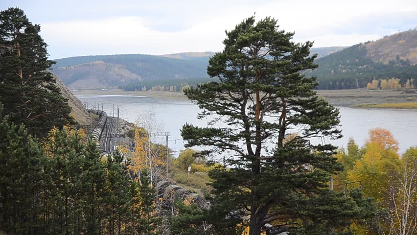 Cargo train is moving on river bank