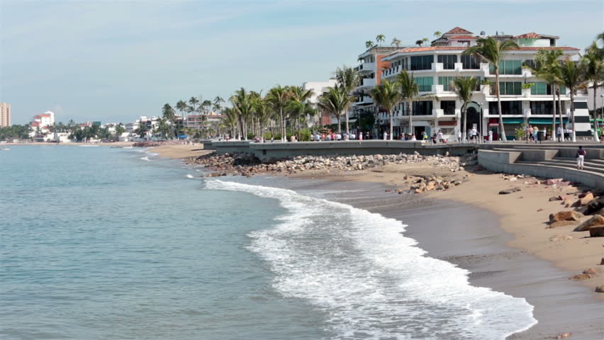 PUERTO VALLARTA, MEXICO NOV 2012: Tourism income. Boardwalk Malecon beach and tourist area shore Banderas Bay, Pacific Ocean. Friends and family stroll and walk along sea shore, restaurants and cafes.