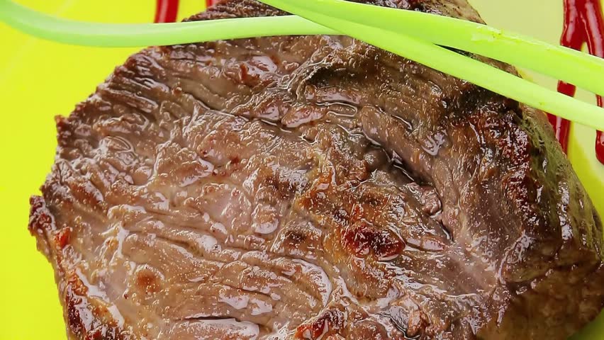 meat savory : grilled beef fillet mignon on green plate with chives and ketchup over wooden table