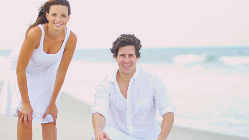 Caucasian parents having fun together young daughter on beach