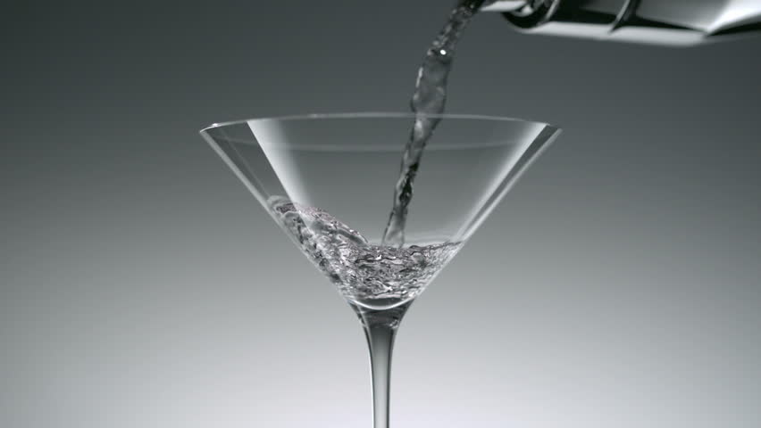 Pouring cocktail into martini glass shooting with high speed camera.