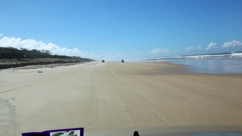 Racing rally motor car on beach, view form driver's seat, plane landing next to car, Fraser Island, Australia