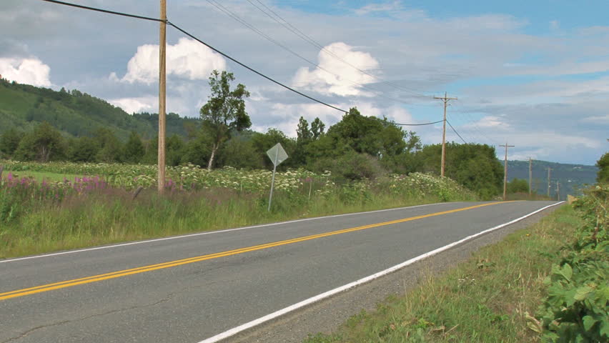 Compact sedan passing by on rural highway.