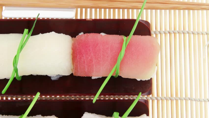Japanese traditional cuisine - Different Types of Nigiri Sushi : Tuna (maguro) Salmon (sake) and Eel (unagi) with Wasabi and Ginger on bamboo mat isolated over white background