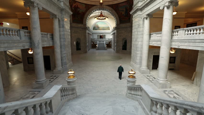 SALT LAKE CITY, UTAH DEC 2012: Utah State Capital man walks through rotunda building. Utah State capital building high on a hill overlooking the city. Interior marble and granite. Corinthian columns.