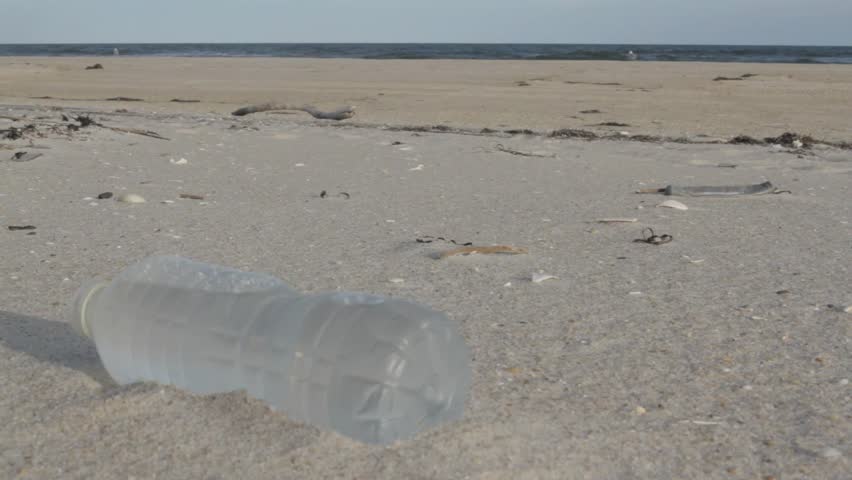 FIRE ISLAND, NY - September 23, 2012: Plastic bottles, styrofoam, balloons and debris lie along beach as ocean washes garbage onto the shore.  Petroleum-based plastic is non-biodegradable. Sequence. 