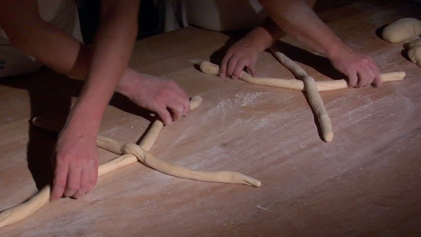 Two baker bread plait braid in spotlight. 