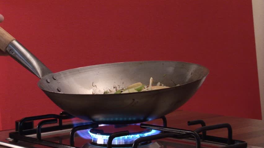 Tossing vegetables and sprouts in a wok