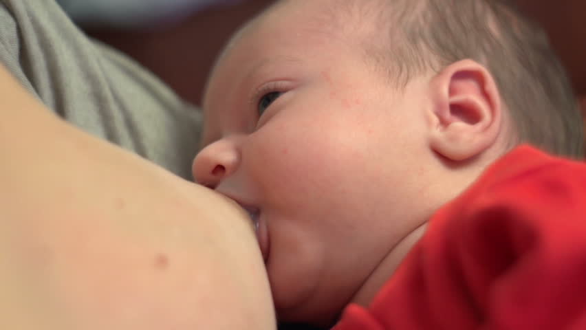 Beautiful one month old baby sucking milk - breastfeeding