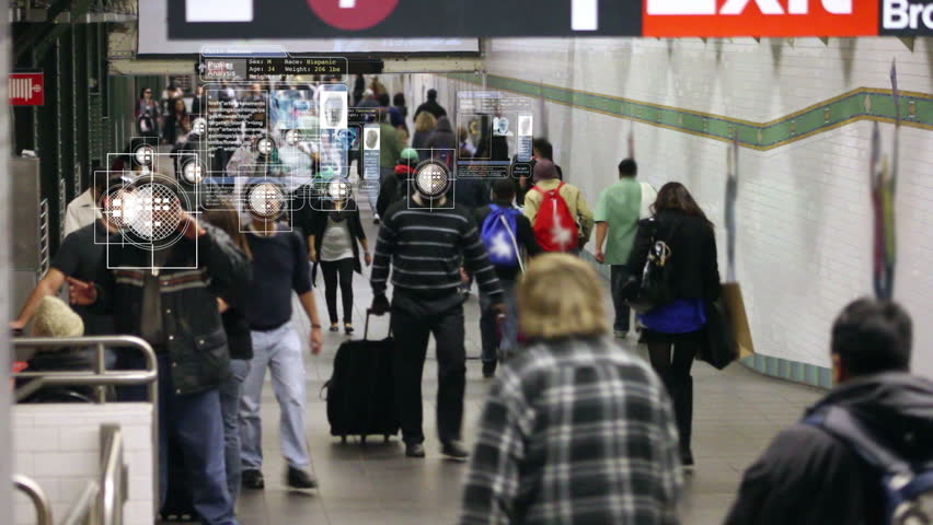 A computer scans a crowded subway tunnel, using facial recognition to show each personâs personal data in a floating display that follows the individual.