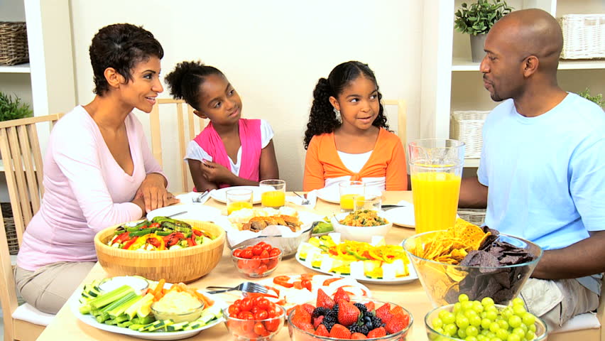 Young ethnic family enjoying a healthy lunch together at home