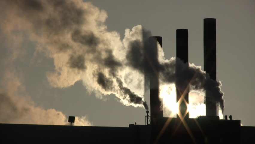 Fumes billow out of a giant smoke stack against the sunny sky (High Definition)