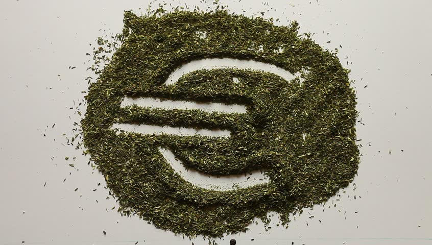 Young adult woman makes euro symbol in dry dill.

