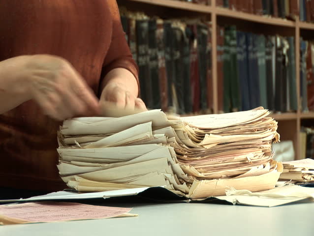 woman's looking for something among old paper documents in file