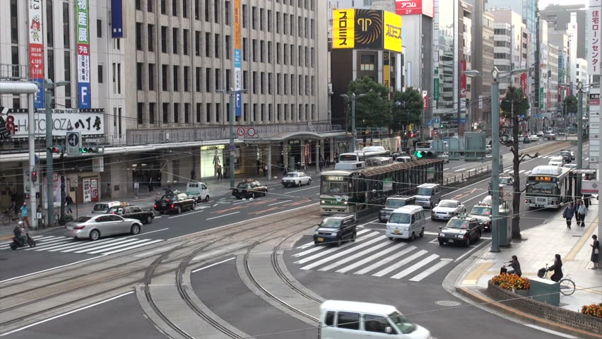 HIROSHIMA, JAPAN - 29 OCTOBER 2012: Busy intersection sees streetscars (trams) and regular traffic flow through during rush hour in Hiroshima, Japan