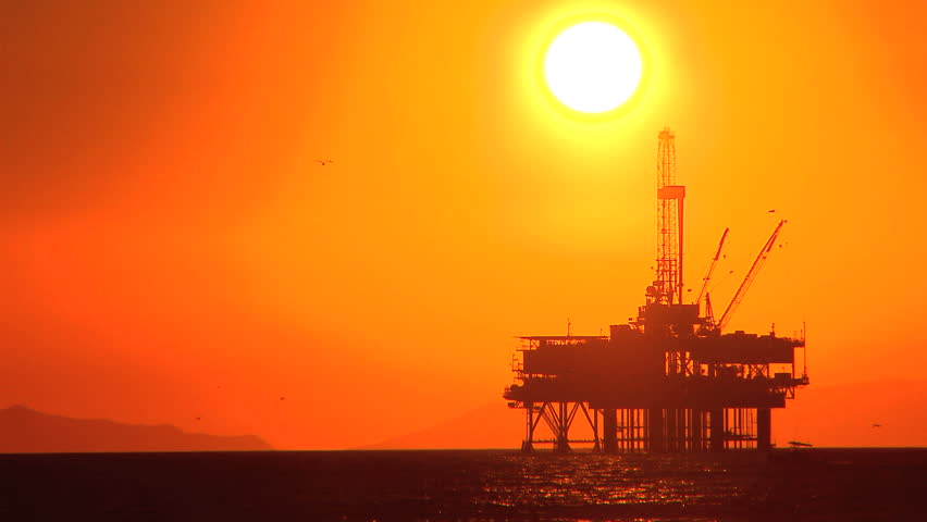 Oil platform in the sea at sunset