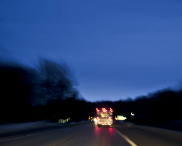 time-lapsed drive behind an on duty ambulance as it makes it's way along a rural road to the hospital. Lights are on, but not flashing. 
