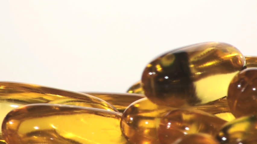 Yellow pill capsules against white - HD LOOP
