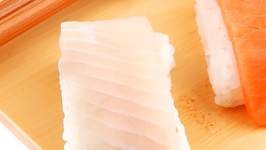 Japanese traditional cuisine - Set of Tuna (maguro) Salmon (sake) and Eel (unagi) Nigiri Sushi with Wasabi and chopstick on wooden plate hidef slow motion