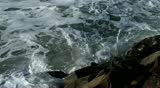 An Ocean Wave Breaking against Rocks and sending a Splash of Water into the Air in Slow Motion.