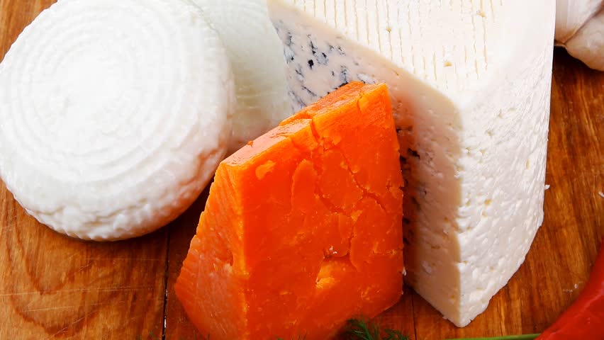 delicatessen french cheese on wooden board with hot peppers and dill hidef intro slow motion