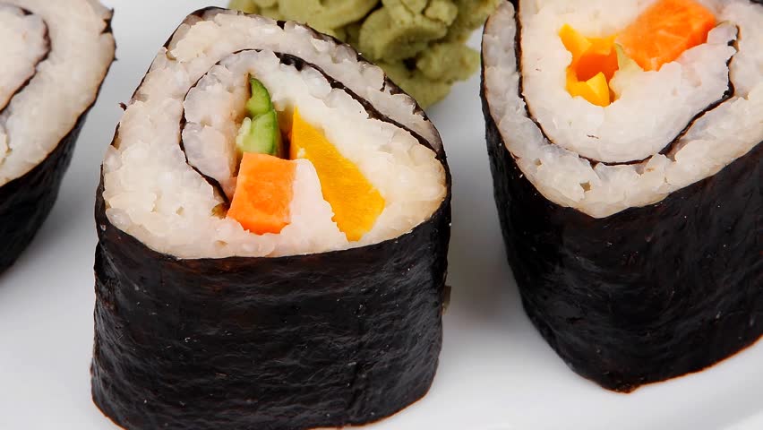 Japanese Traditional Cuisine - California Roll with Salmon (sake) Cream Cheese and Tuna (maguro) . on white dish with sticks isolated over white background