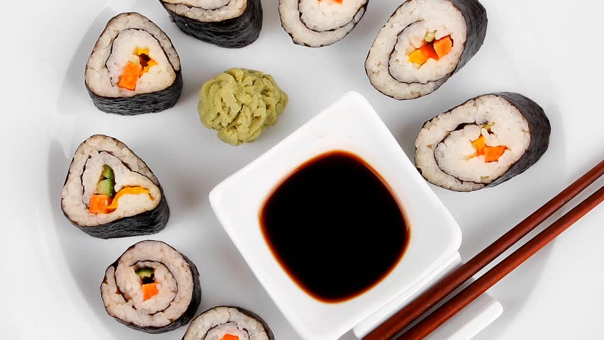 Maki Sushi : Maki Rolls and California rolls made of fresh raw Salmon(sake) Tuna(maguro) and Eel(unagi) . on white dish with sticks hidef slow motion intro