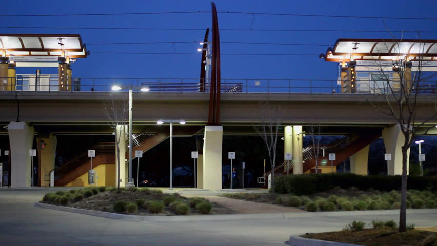 Public Transportation Station in the evening with two trains stopping and passing