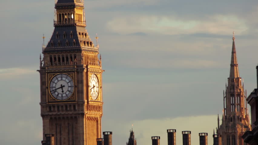 A stationary view of Big Ben clock tower in London. The dial part of it can be seen among the chimneys of surrounding houses