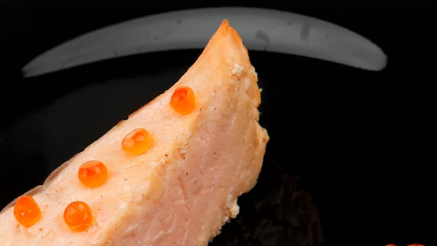 savory fish : norwegian salmon fillet roasted with green onion pen red caviar in spoon on black dish hidef slow motion intro
