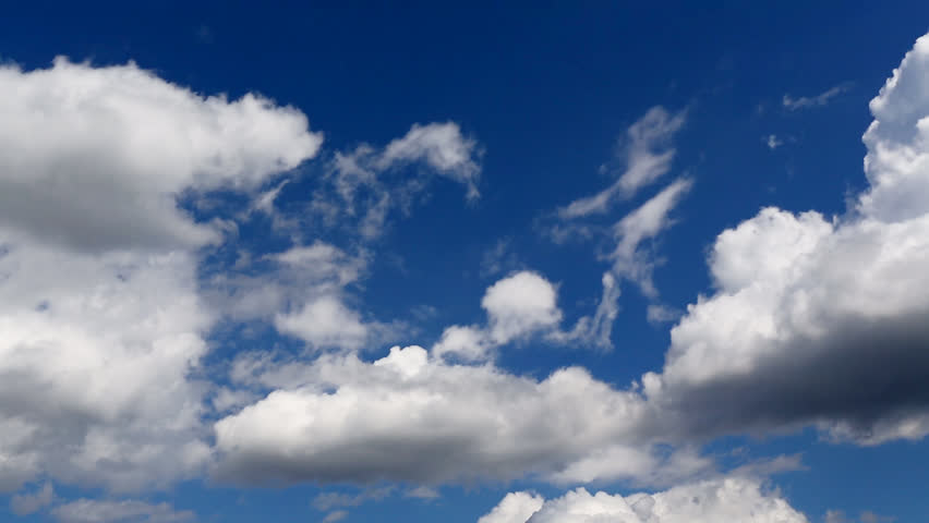 Time lapse clip of white fluffy clouds over blue sky