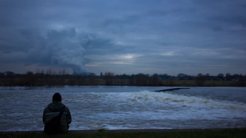 Figure Sitting Infront Of River Rapids And Power Station Timelapse