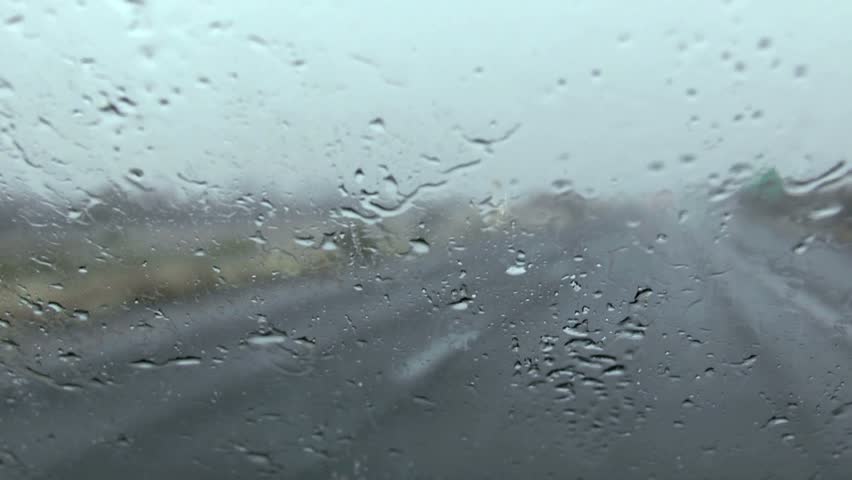Rain splatters car windshield during storm, creates difficult driving conditions. 1080p