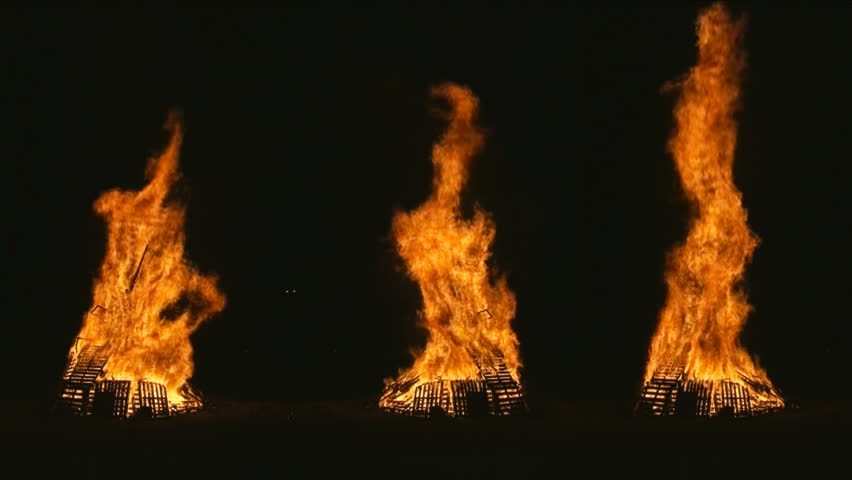 Fire pyre three stacks - Three stacks of wood piles burning, obtained by mixing different footage. Great for backgrounds.