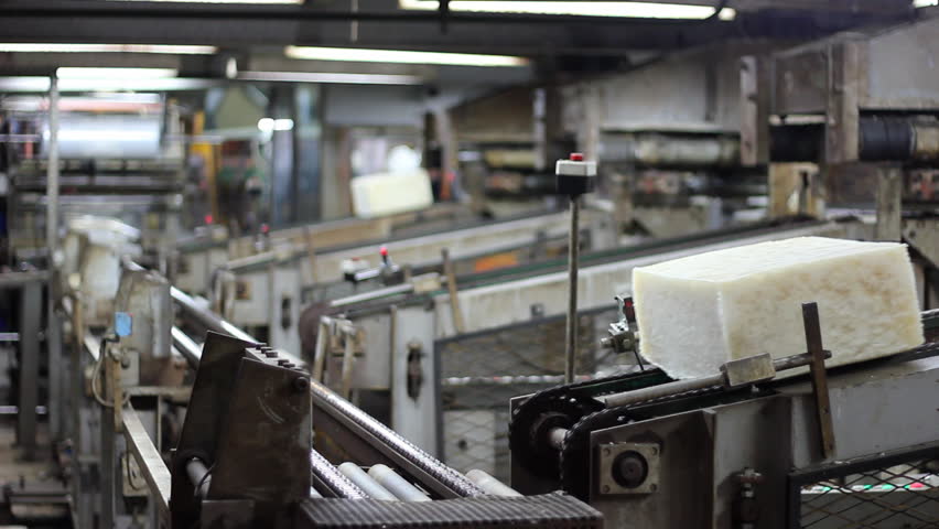 Manufacturing synthetic rubber in petrochemical plant, raw materials for making rubber wares. Compressing in the form of a cube and packing. Workers controlling production