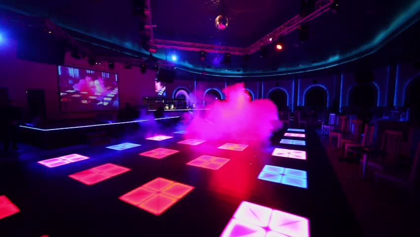 Fog covers dance floor of nightclub with illumination