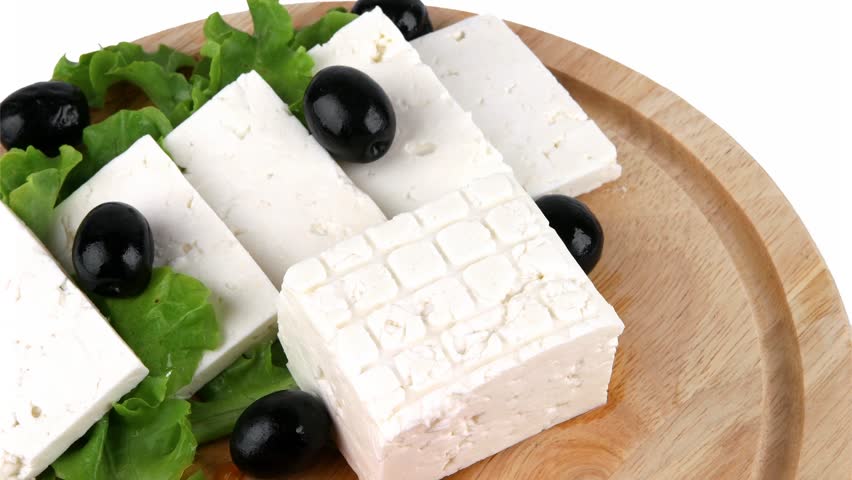 feta cheese with olives on wooden plate