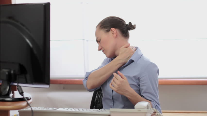 Young woman suffering from neck pain while working on computer