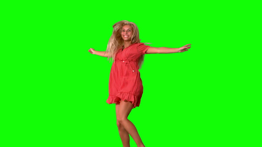 Attractive blonde jumping on green screen in slow motion