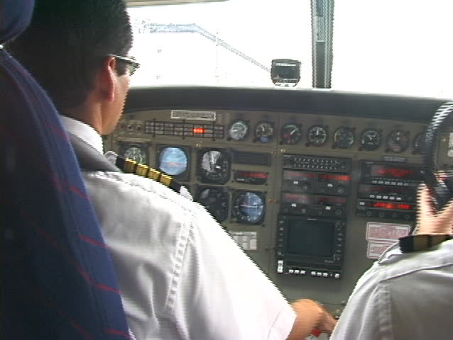 2 pilots inside cockpit prepare for takeoff